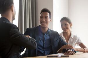 Smiling Diverse Couple Handshaking With Financial Advisor